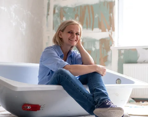Frau in Badewanne während Sanierung Badezimmer